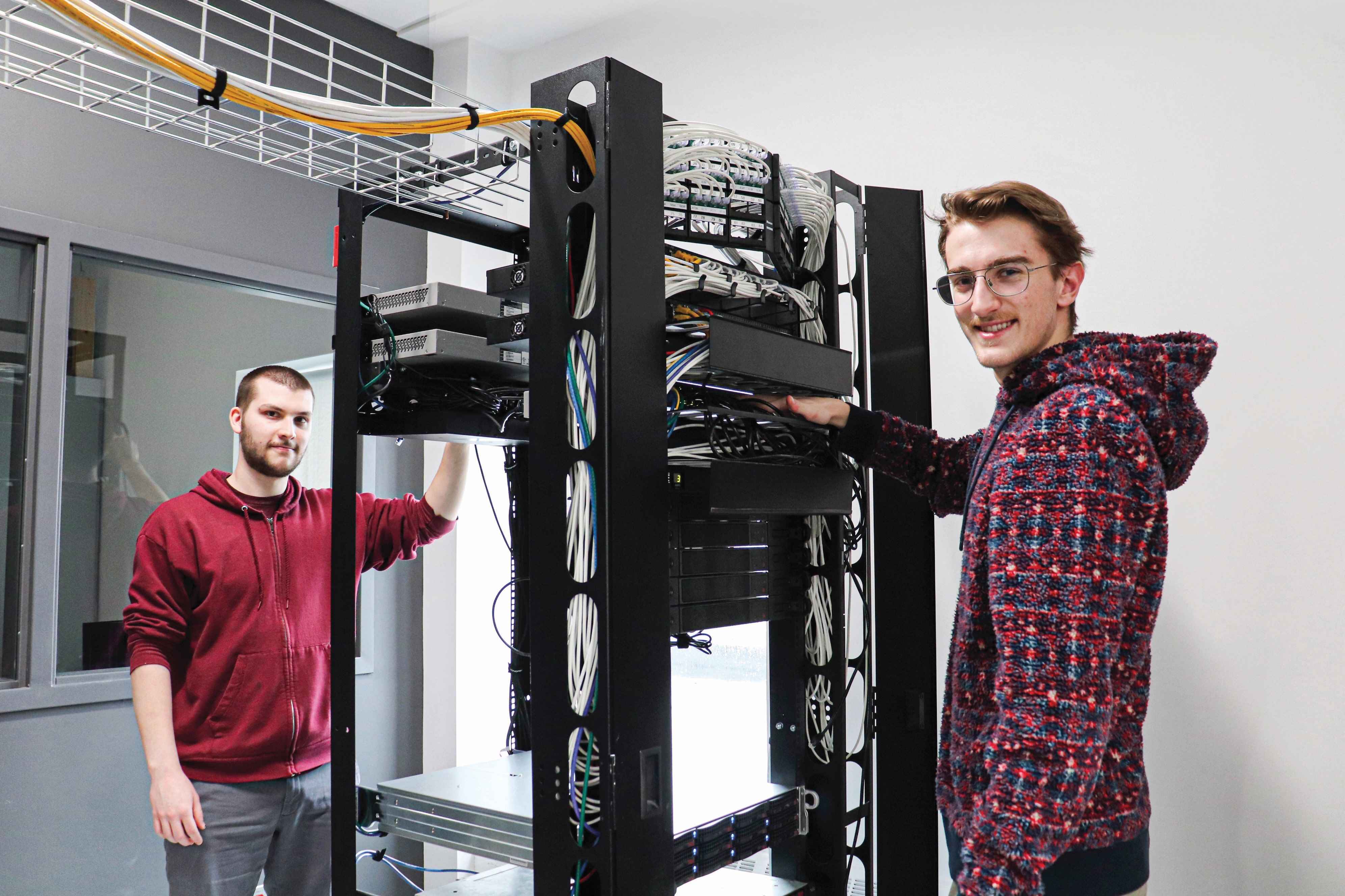 Deux étudiants devant des infrastructures informatiques au Cégep de Lévis.